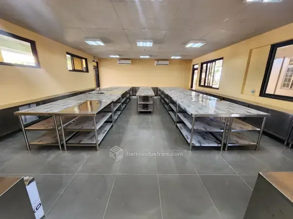 ISPSC 2026 — rows of stainless-steel work tables in the school room